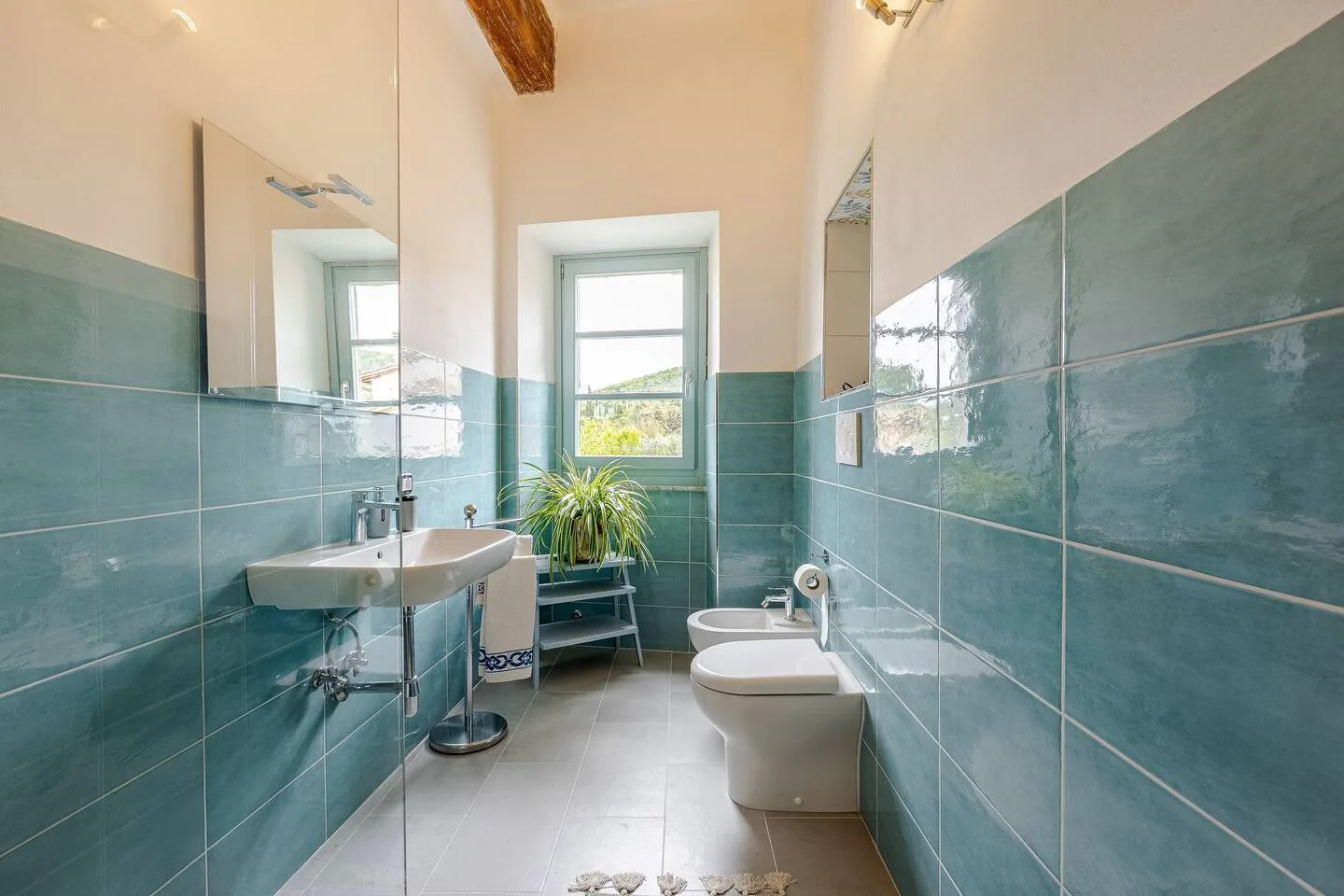 Bagno comune del primo piano con rivestimenti azzurri